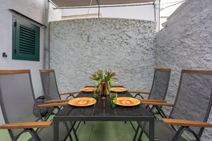 Ein Esstisch mit Stühlen, einer Blumenvase und Gläsern.