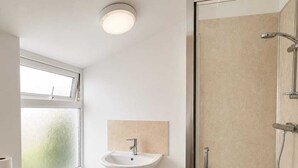 Un baño con inodoro, lavamanos y ducha.
