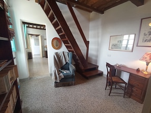 A room with a wooden staircase, a desk with a lamp, a chair, and a bookshelf. - A charming retreat witha nice view and a garden with barbecue and Jacuzzi (Gombitelli)
