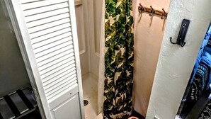 A bathroom with a shower curtain, a towel rack, and a door with a handle.