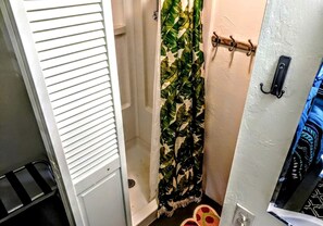 A bathroom with a shower curtain, a towel rack, and a door with a handle.