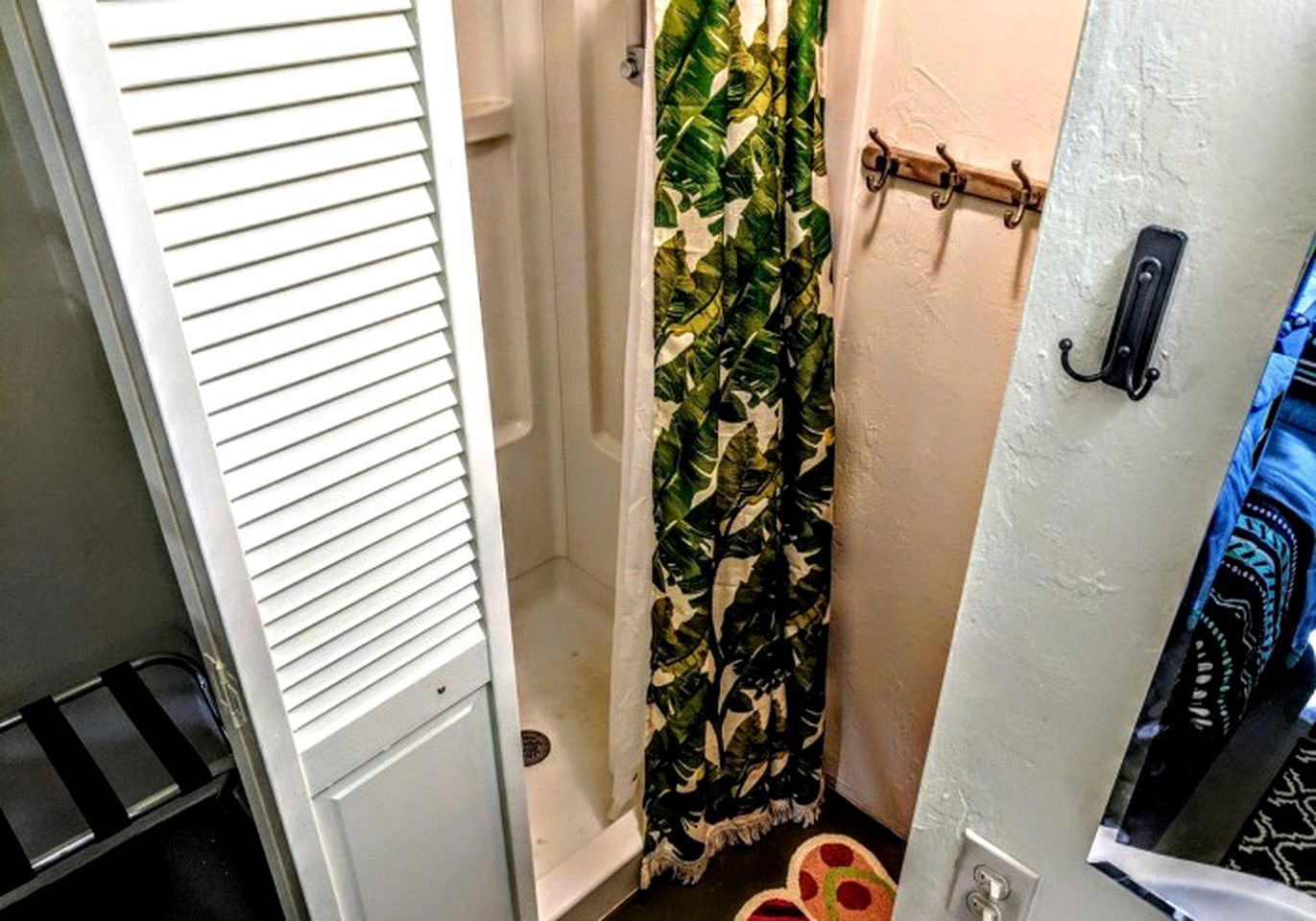 A bathroom with a shower curtain, a towel rack, and a door with a handle.