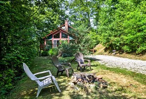 A rustic cabin with a chimney, surrounded by lush greenery and a gravel path. - Spacious Vacation Cabin with a Fire Pit in Bryson City, North Carolina (Bryson City)