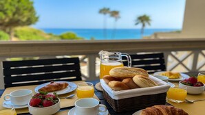 Desayuno con cruasanes, fresas, jugo y vistas al océano.