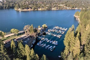 Ilmakuva venesatamasta, jossa veneet ovat kiinni laitureissa. Satamaa ympäröi tiheä metsä ja sen vieressä on järvi.