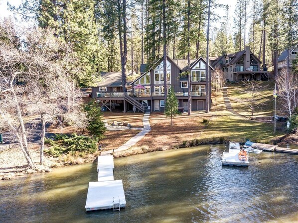Un chalet doté d’un quai, entouré d’arbres et bordé par une rivière.