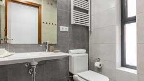 Un baño moderno con inodoro, lavamanos y toallero.