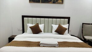 A neatly made bed with a headboard, two pillows, and a folded blanket. - HOTEL KAMAL RESIDENCY BY UK SEASON (Tehri)