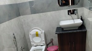A bathroom with a toilet, bidet, sink, and cabinet. - HOTEL KAMAL RESIDENCY BY UK SEASON (Tehri)