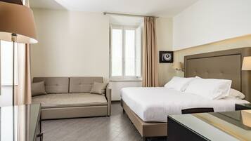 Une chambre d’hôtel avec un lit, un canapé, un bureau et une fenêtre.