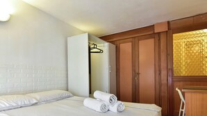 Een hotelkamer met een bed, een kledingkast en een badkamer met douchegordijn.