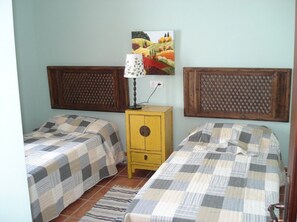 A room with two beds, a nightstand, a lamp, and a painting on the wall. - Villas Yaiza, Casa de la Villaflor (Yaiza)
