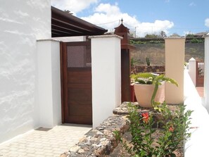 A white building with a wooden door, a stone pathway, and a potted plant. - Villas Yaiza, Casa de la Villaflor (Yaiza)