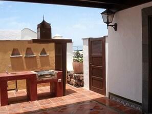 An outdoor patio with a grill, a potted plant, and a door. - Villas Yaiza, Casa de la Villaflor (Yaiza)