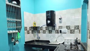 Una cocina con un lavamanos, dispensador de agua y estufa.