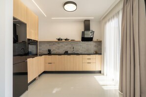 Eine moderne Küche mit Holzschränken, einer schwarzen Arbeitsplatte und einer Dunstabzugshaube.