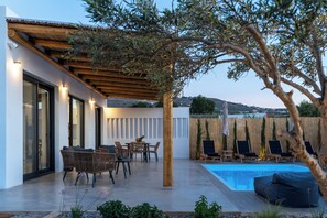 Eine moderne Außenpatio mit Pool, Holz-Pergola und Sitzbereichen.