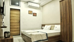 Un dormitorio con cama de madera, televisión, aire acondicionado y armario.