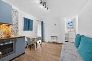 A compact living space with a kitchenette, a dining area, a sofa, and a small table. - Vista Marina Seaside Comfort (Santa Cruz de Tenerife)