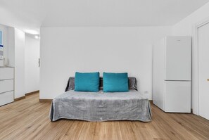 A bedroom with a bed, a white wardrobe, and a white refrigerator. - Vista Marina Seaside Comfort (Santa Cruz de Tenerife)