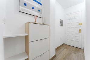 A hallway with a white wardrobe, a door with a handle, and a wall-mounted light switch. - Vista Marina Seaside Comfort (Santa Cruz de Tenerife)