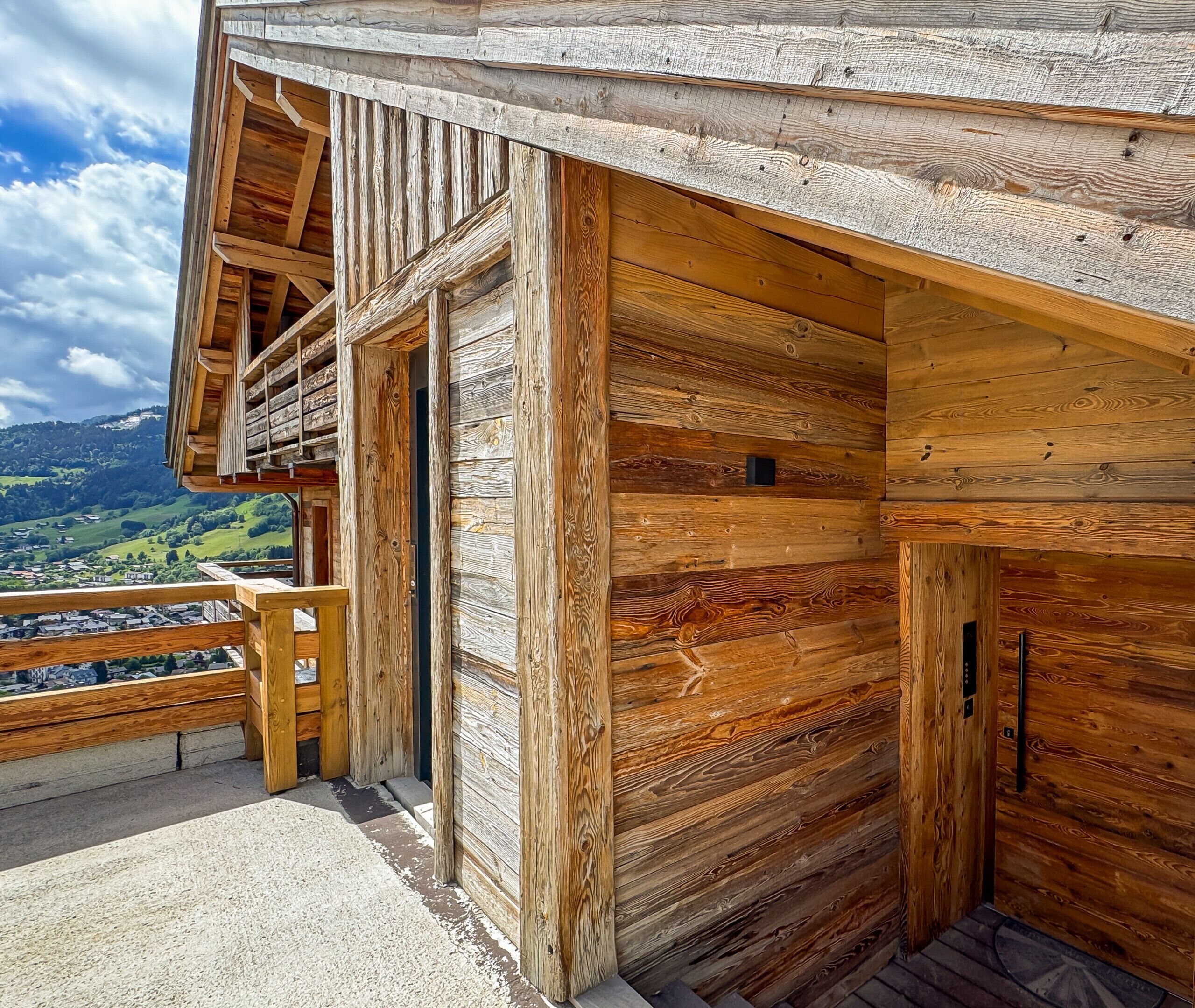 Eine Holzhütte mit einem Balkon mit Blick auf ein Tal.