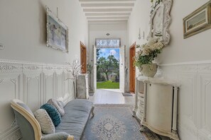 A hallway with a bed, a dresser, a mirror, and a door leading to a garden. - Villa Mon Paradis 15 Garden Hot Tub Pet Friendly (Lucca)