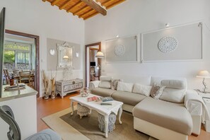 A living room with a sofa, coffee table, and decorative items. - Villa Mon Paradis 15 Garden Hot Tub Pet Friendly (Lucca)