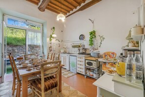A kitchen with a dining table set, a refrigerator, and a microwave. - Villa Mon Paradis 15 Garden Hot Tub Pet Friendly (Lucca)