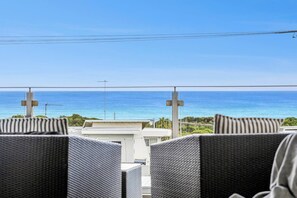 A balcony with wicker chairs and a view of the ocean. - Ocean Views - just metres from the beach! (Ocean Grove)