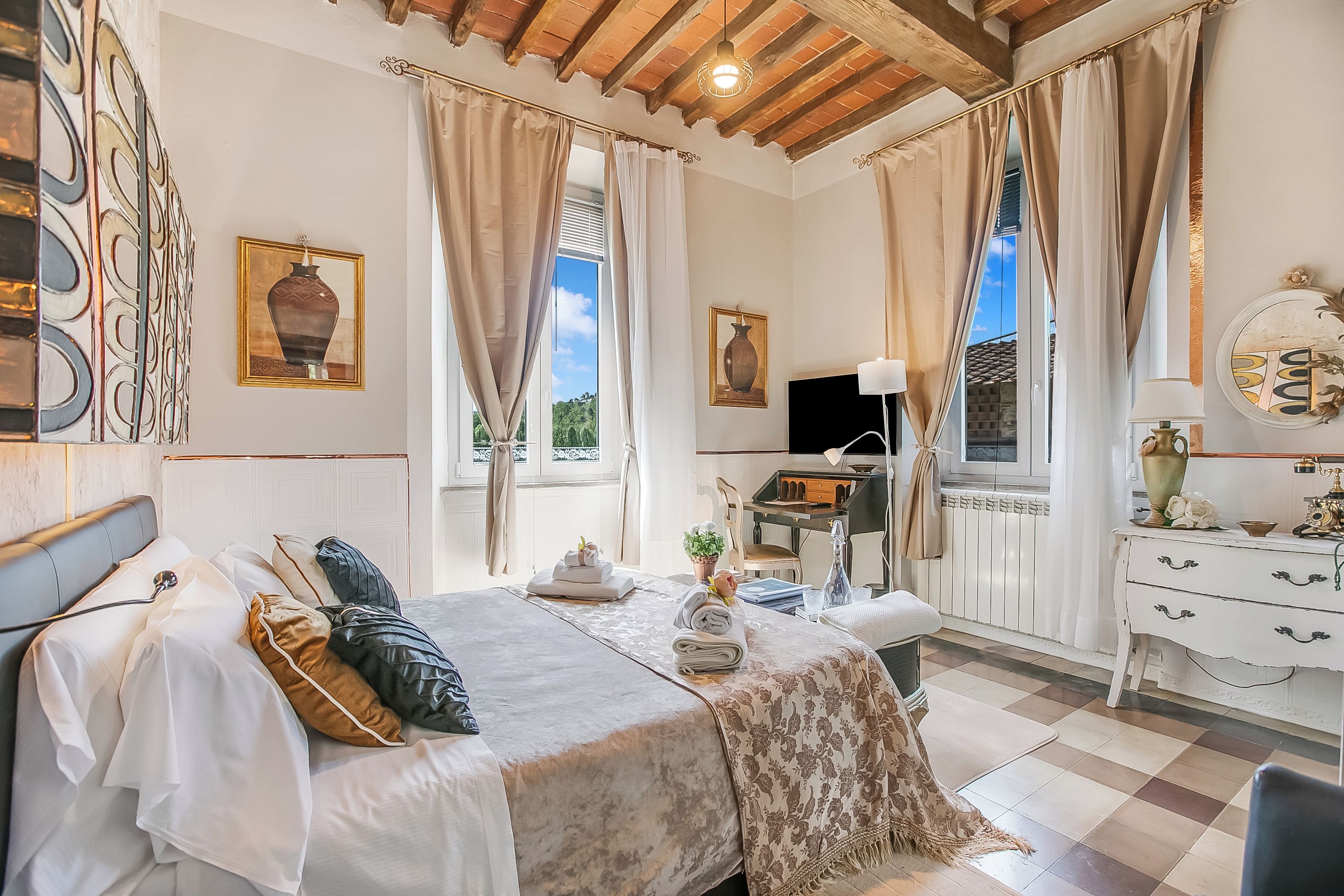Ein helles Schlafzimmer mit Bett, Schreibtisch und Kommode.