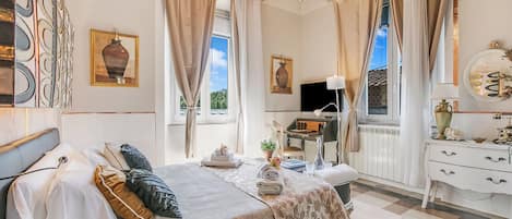 A well-lit bedroom with a bed, a desk, and a dresser.