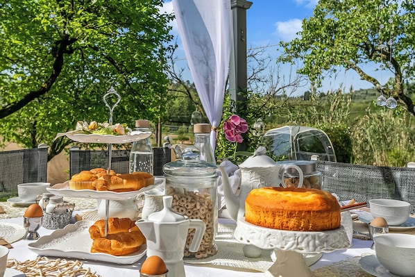 Ein Essplatz im Freien mit Gebäck, Kuchen und verschiedenen Besteckstücken.