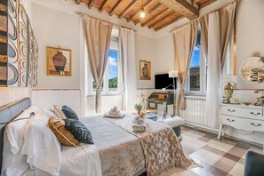 Ein helles Schlafzimmer mit Bett, Schreibtisch und Kommode.