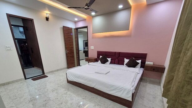 Un dormitorio moderno con una cama grande, un ventilador de techo y un espejo.