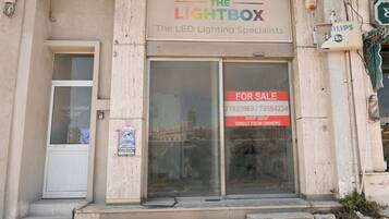 Ein Gebäude mit einem Schild für 'The Lightbox – The LED Lighting Specialists' und einem 'Zu verkaufen'-Schild.