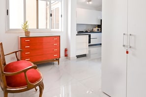 A modern kitchen with white cabinets, a red wooden cabinet, and a microwave on the counter. - Yacht Marina View - Modern 3 Bdrs Apart M (Msida)