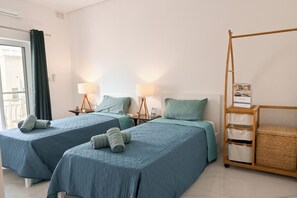 A hotel room with two beds, each with a pillow and a lamp. There is a wooden ladder and a wicker basket on the right side. - Yacht Marina View - Modern 3 Bdrs Apart M (Msida)