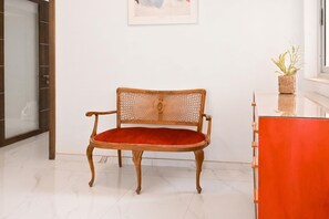 A wooden chair with a woven backrest and a red cushion in a room with a white wall and a glass door. - Yacht Marina View - Modern 3 Bdrs Apart M (Msida)