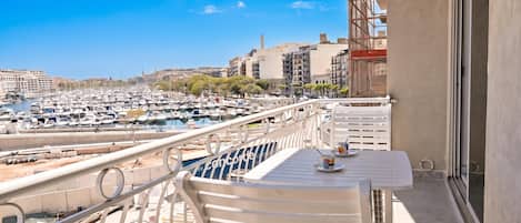 A balcony with a view of a marina and cityscape.