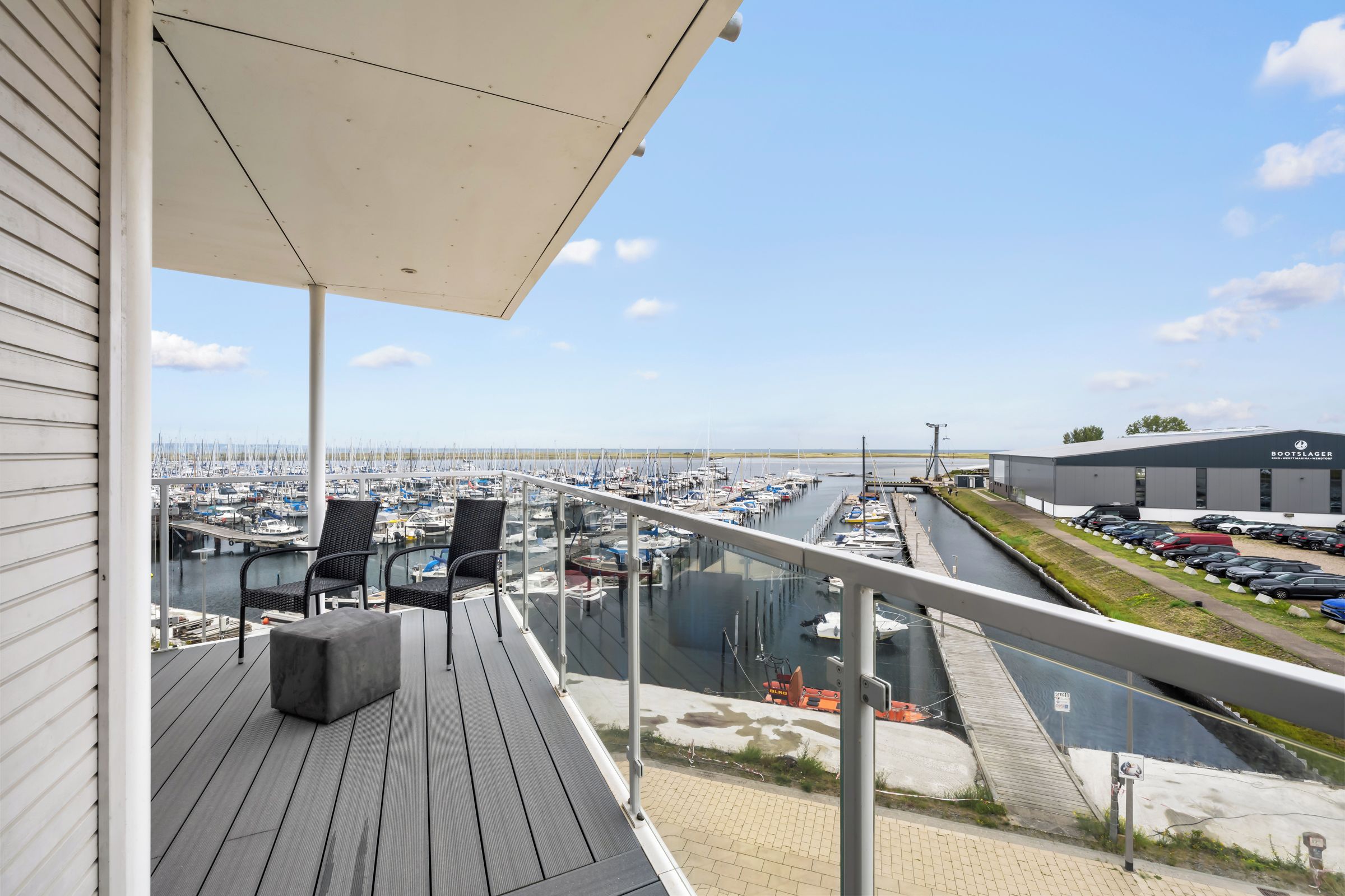 Ein Balkon mit Blick auf einen Yachthafen und einen Parkplatz.