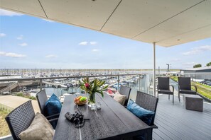 Un espace de restauration en plein air avec vue sur un port de plaisance.