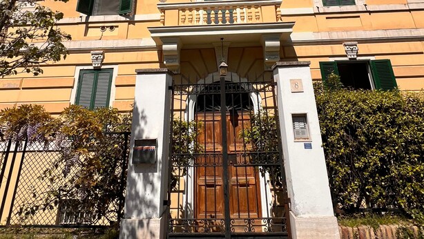 A two-story building with a central entrance, a balcony, and a gate. - Gianicolo Hill Apartment (Roma)