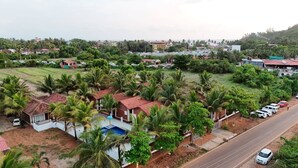 Un barrio residencial con casas, piscina y coches estacionados.