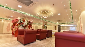 A hotel room with a marble floor, red sofas, and floral decorations. - EENNRA ATTRAYEE GUEST HOUSE  & BANQUET (Balurghat)