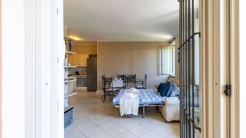 Una stanza con un letto, un tavolo, sedie, angolo cottura e bagno.