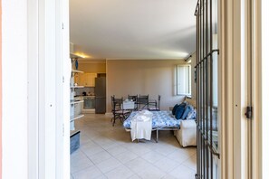 Ein Zimmer mit Bett, Tisch, Stühlen, einer Küchenzeile und einem Badezimmer.