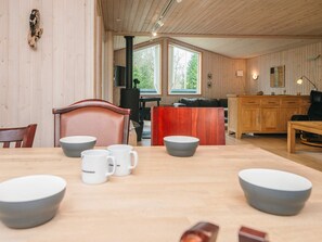 A wooden interior with a dining table, chairs, and a kitchen area. - 6 Person Holiday Home in Herning (Herning)