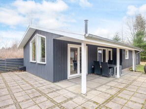 A modern, single-story building with a covered patio area, large windows, and a chimney. - 6 Person Holiday Home in Herning (Herning)
