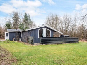 A single-story house with a dark exterior, a large window, and a covered porch area. - 6 Person Holiday Home in Herning (Herning)